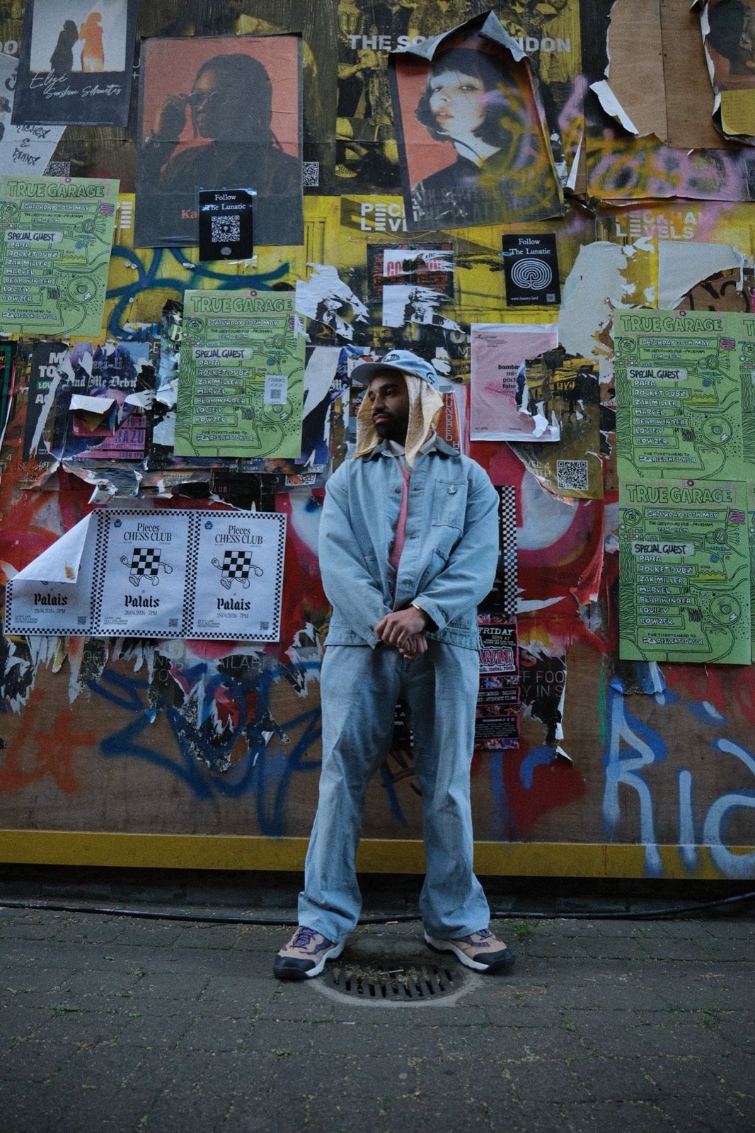 Conrad Kira against a poster-covered wall